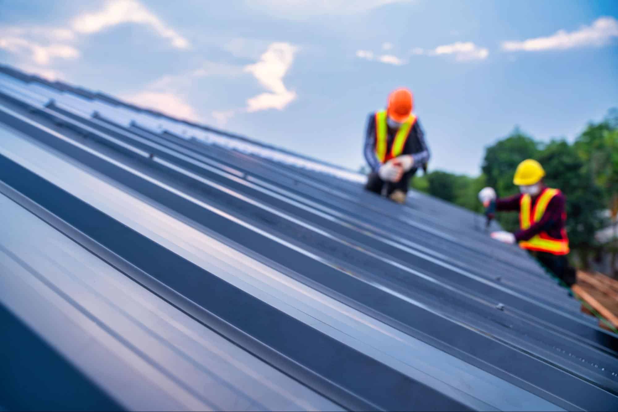 Workers replacing shingles on a residential roof